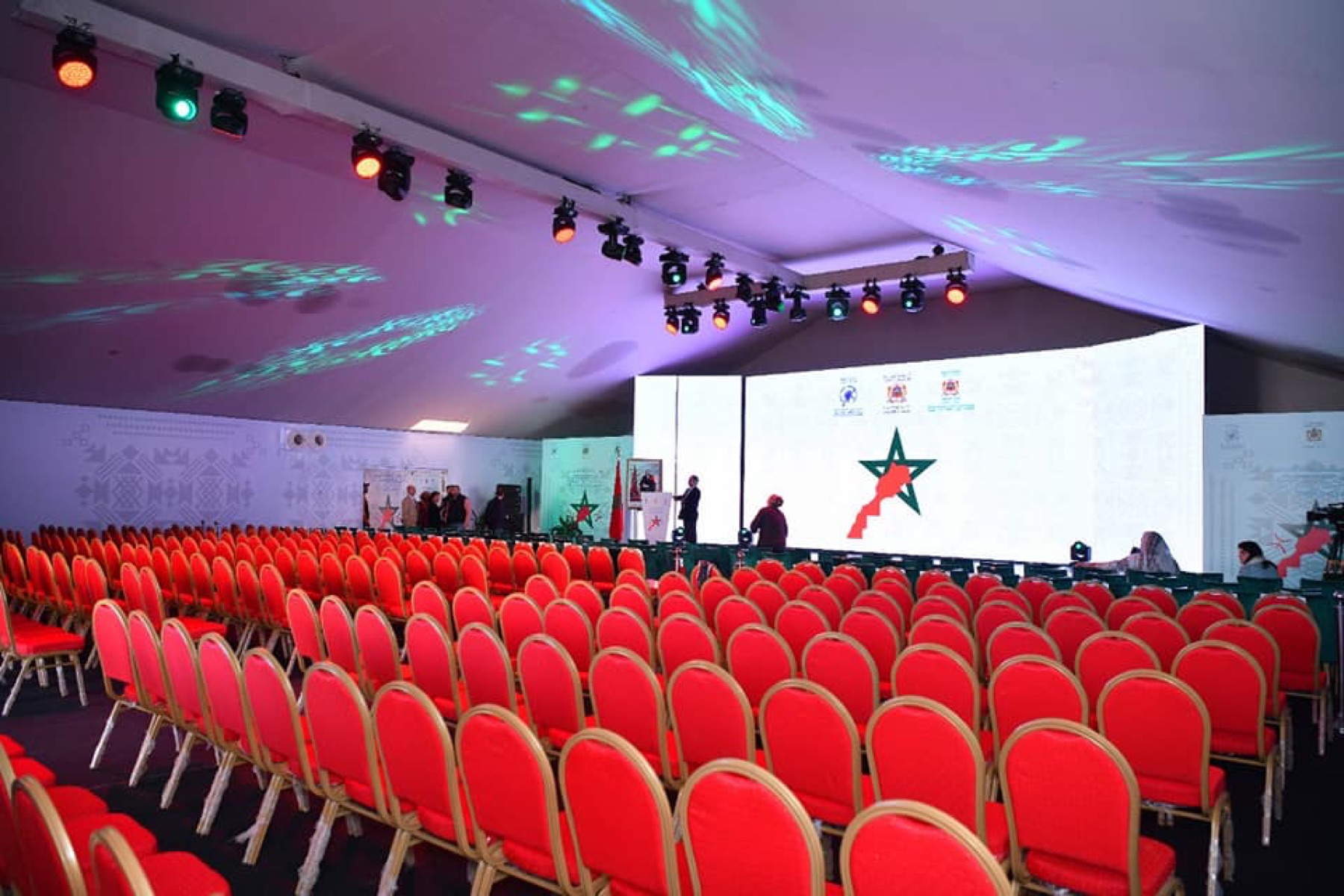 Salle de conférence avec sièges rouges et écran à Khémisset
